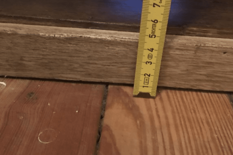 Measuring the door threshold with a ruler.